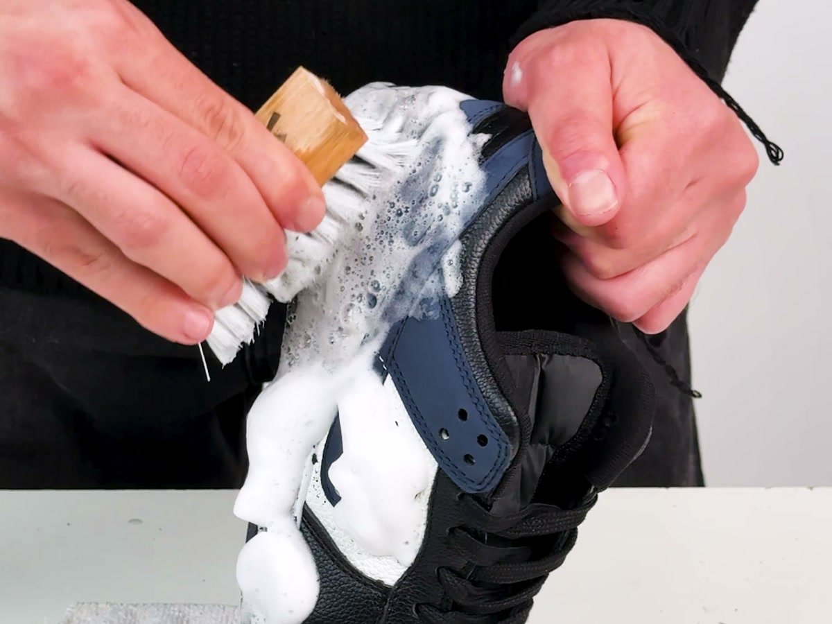 Scrubbing a sneaker with the Laundor beechwood brush